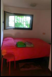 - un lit rouge dans une chambre avec fenêtre dans l'établissement La casa nel cortile-Free parking, à Milan