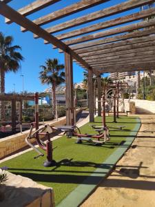 a row of exercise equipment in a park at Seaside Apartment in Arenales del Sol