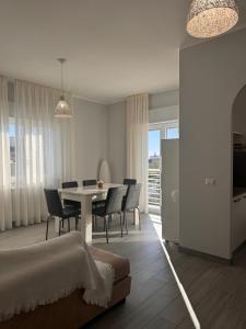 a living room with a dining room table and chairs at La Casa Vista Mare in Fregene