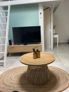een salontafel in een woonkamer met een tv bij Appartement chaleureux climatisé in La Ciotat