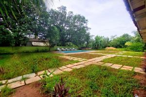 a backyard with a swimming pool and a lawn at Luxury 4bhk Villa with Swimming Pool Near Calangute & Baga in Nagoa-Bardez