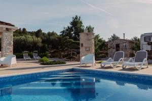 a swimming pool with lounge chairs and a swimming pool at The Secret Garden Villa in Vela Luka