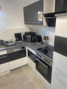 una cocina con armarios y electrodomésticos en blanco y negro en Appartment Kuschelecke, en Kiefersfelden