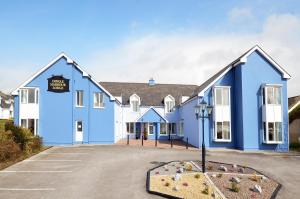 ein blau-weißes Gebäude mit einem Parkplatz in der Unterkunft Dingle Harbour Lodge B&B in Dingle