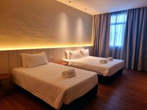 Postel nebo postele na pokoji v ubytování Roxy Hotel Malihah
