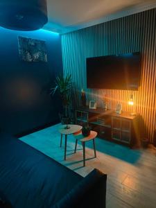 a living room with a large television and a table at obonheurdu paon in Arques