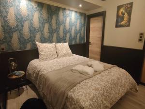 a bedroom with a bed with towels on it at obonheurdu paon in Arques