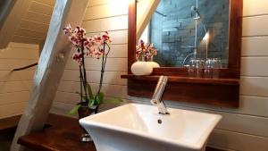 a bathroom with a sink and a mirror and flowers at Rødseter Gjestegård in Fjarland +22 photos