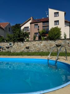 a swimming pool in front of a building at Penzion Eden Pálava in Klentnice