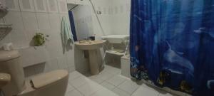 ein Badezimmer mit Waschbecken, Toilette und Duschvorhang in der Unterkunft Maison Kemmiu Kinshasa in Kinshasa