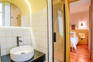 a bathroom with a sink and a bedroom at Le Falcoz in Saint-Jean-de-Maurienne