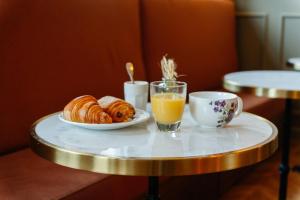 a table topped with a plate of croissants and orange juice at Le Falcoz in Saint-Jean-de-Maurienne