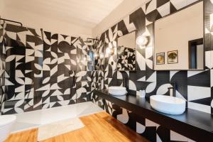 a black and white bathroom with two sinks and a mirror at Le Falcoz in Saint-Jean-de-Maurienne