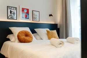 a large bed with white sheets and pillows on it at Le Falcoz in Saint-Jean-de-Maurienne