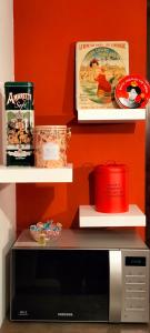 un forno a microonde appoggiato su un bancone accanto agli scaffali di Casa Azalea a Lainate