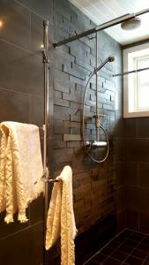 a bathroom with a shower with towels and a brick wall at Rødseter Gjestegård in Fjarland