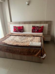 a bedroom with a large bed with red pillows at Eraya Elegance Inn in Chhatikara