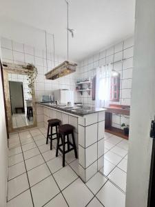 Una cocina con una encimera y algunos taburetes en ella. en TRANCOSO, Ap Center Braga, en Trancoso