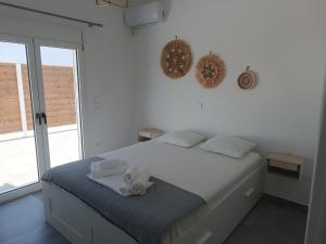 Un dormitorio blanco con una cama con toallas. en Blue & Green, en Longá