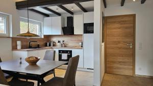 a kitchen with a table and a wooden door at Landhaus-Wald-und-See-3 in Koosbüsch