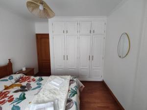a bedroom with a bed and a mirror on the wall at Unmei in Lagoa +3 photos