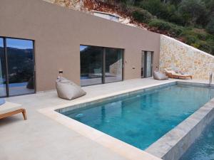 a swimming pool in the middle of a house at Maradato Villas in Mikros Gialos