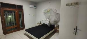 ein kleines Bett in einem Zimmer mit Fenster in der Unterkunft Maison Kemmiu Kinshasa in Kinshasa