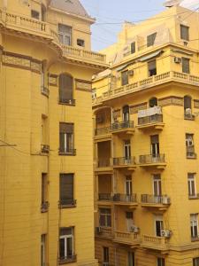 カイロにあるPhilo Hotelの側面にバルコニーがある黄色い建物