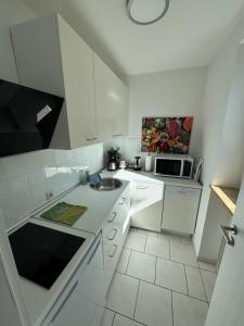 a white kitchen with a sink and a microwave at Seefelder Berge und Seen Appartements in Seefeld +26 photos