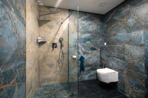 a bathroom with a toilet and a glass shower at Castle Apartments in Zvolen