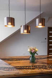 a vase of flowers sitting on a table with lights at Castle Apartments in Zvolen