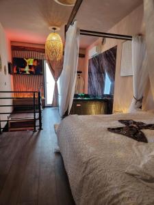 a bedroom with a large bed and a chandelier at Loveroom Romantique La Mure in La Mure