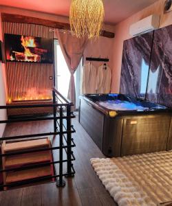 a hot tub in a room with a fireplace at Loveroom Romantique La Mure in La Mure