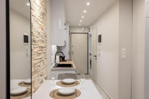 une cuisine avec une table avec des assiettes et des verres à vin dans l'établissement Urban Pulse by #db premium stay apartments, à Thessalonique 61 autres photos