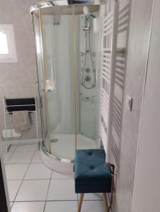 a bathroom with a shower and a blue chair at Maison proche Etretat, Le Havre in Montivilliers