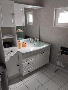 a white bathroom with a sink and a mirror at Maison proche Etretat, Le Havre in Montivilliers