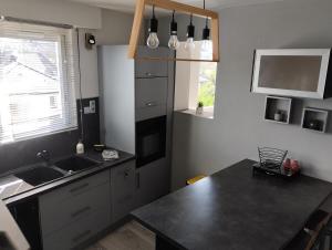 a kitchen with a black counter top and a sink at Maison proche Etretat, Le Havre in Montivilliers +5 photos
