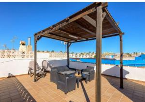 a pergola over a patio with a pool at Lolena Calas De Torrevieja in Torrevieja