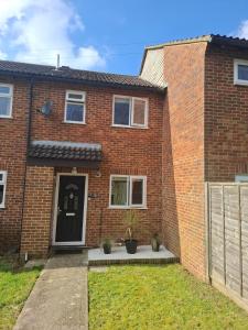 a brick house with a black door at Cosy Manorfield Holiday Home in Kent