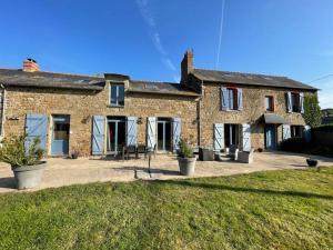 a large brick house with a patio in front of it at chambre St Malo Cancale in Saint-Méloir-des-Ondes