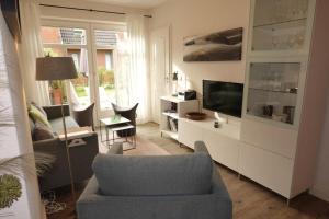 a living room with a chair and a television at Sommergarten in Wyk auf Föhr