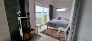 a bedroom with a fireplace and a bed and a window at Aurora Jukkas Riverside Lodge in Jukkasjärvi