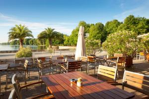 an outdoor patio with tables and chairs and an umbrella at Courtyard by Marriott Hannover Maschsee in Hannover