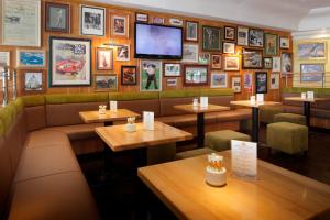 a restaurant with tables and a tv on the wall at Courtyard by Marriott Hannover Maschsee in Hannover