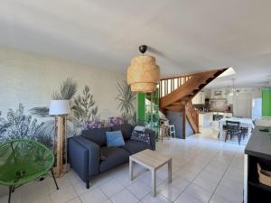 a living room with a blue couch and a kitchen at La Maison Siméon in Amboise