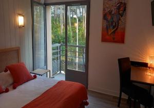 a bedroom with a bed and a desk and a window at Les Jardins de L'Ocean - Climatisé in Biscarrosse-Plage