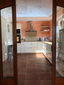 a kitchen with white cabinets and a tile floor at Piscine et tennis privés à proximité Aix en Provence in Rousset