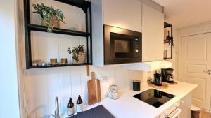 a kitchen with a white counter top with a microwave at Leilighet midt i Sokndal sentrum in Sokndal