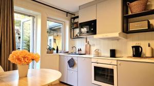 a kitchen with a table and a vase with orange flowers at Leilighet midt i Sokndal sentrum in Sokndal +14 photos