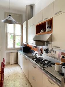 a kitchen with white cabinets and a stove top oven at CASA MAGNOLIA in Venice-Lido +18 photos